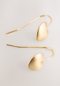 Gold-tone earrings with a brushed metallic heart design and elongated hook back. Smooth surface, minimalist shape.