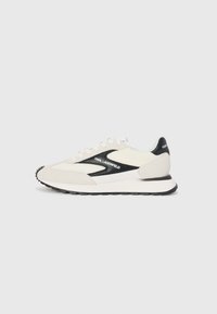 Hvit og grå sneaker med svarte detaljer, med et mesh-overdel og semsket skinn, snøring, og gummisåle.