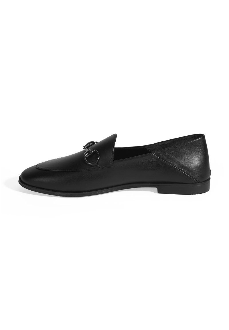 Schwarze Lederloafer mit einer abgerundeten Spitze, die zwei kreisförmige Hardware-Akzente an der Vorderseite und eine glatte Textur aufweist. Flache Gummisohle.