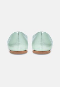 Ballerines en cuir vert menthe avec un bout arrondi, texture lisse et design minimaliste. Semelle en caoutchouc beige sans accents visibles.