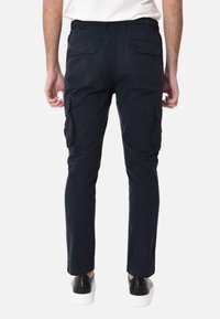 Pantaloni cargo navy con vita regolabile tramite cordino, due tasche laterali e due tasche posteriori. Il tessuto sembra liscio con una leggera lucentezza.