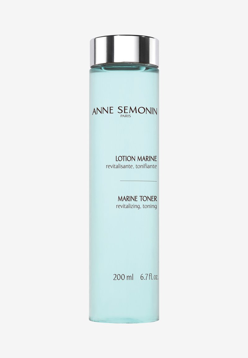 Bouteille en verre cylindrique claire avec un capuchon argenté ; contient un liquide bleu étiqueté "Toner Marin", 200 ml, avec du texte en français et en anglais.