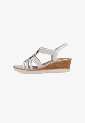 Wedge sandal in light silver with multiple strap design and metallic accents. Cork platform sole with textured detailing. Comfortable fit.