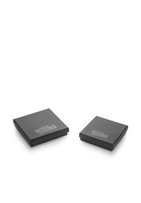 Dos cajas cuadradas negras con un acabado mate, que presentan un logo en relieve de "TRUE REBELS!" en la superficie superior, una ligeramente más grande que la otra.