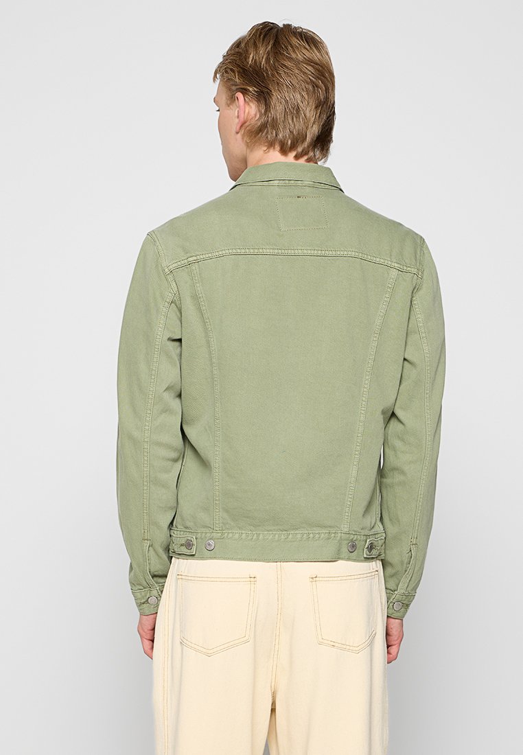 Giacca di jeans verde con chiusura a bottoni, due tasche posteriori e colletto classico. Presenta cuciture a contrasto e una finitura texture.