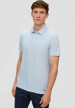 Lichtblauwe polo shirt, gestructureerde stof, drie-knopen placket, korte mouwen, logo-accent op de zoom, gecombineerd met donkere broek.