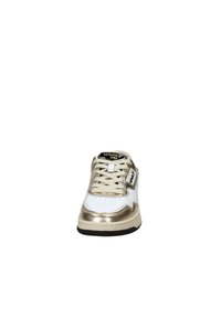 Sneaker bianca con dettagli metallici dorati e suola nera. Presenta un design con lacci, punta perforata e marchio sulla linguetta e sul lato.