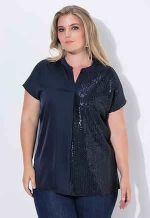 Marineblouse met korte mouwen; zachte stof aan de ene kant en glinsterende textuur aan de andere kant; met kraag ontwerp, iets losse pasvorm.