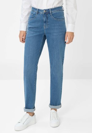 Hellblaue Jeans aus Denim mit geradem Schnitt, mit umgeschlagenen Säumen, vier Taschen und einem Knopfverschluss am Bund. Kombiniert mit weißen Sneakers.