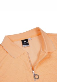 Světle oranžová polo košile na zip s texturovaným vzorem, kontrastním límcem, stříbrným zipem a štítkem s velikostí "S."