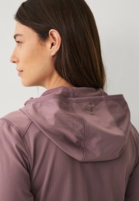 Giacca con cappuccio in tessuto mauve tenue con texture liscia, caratterizzata da un piccolo logo sul retro e cuciture a contrasto.