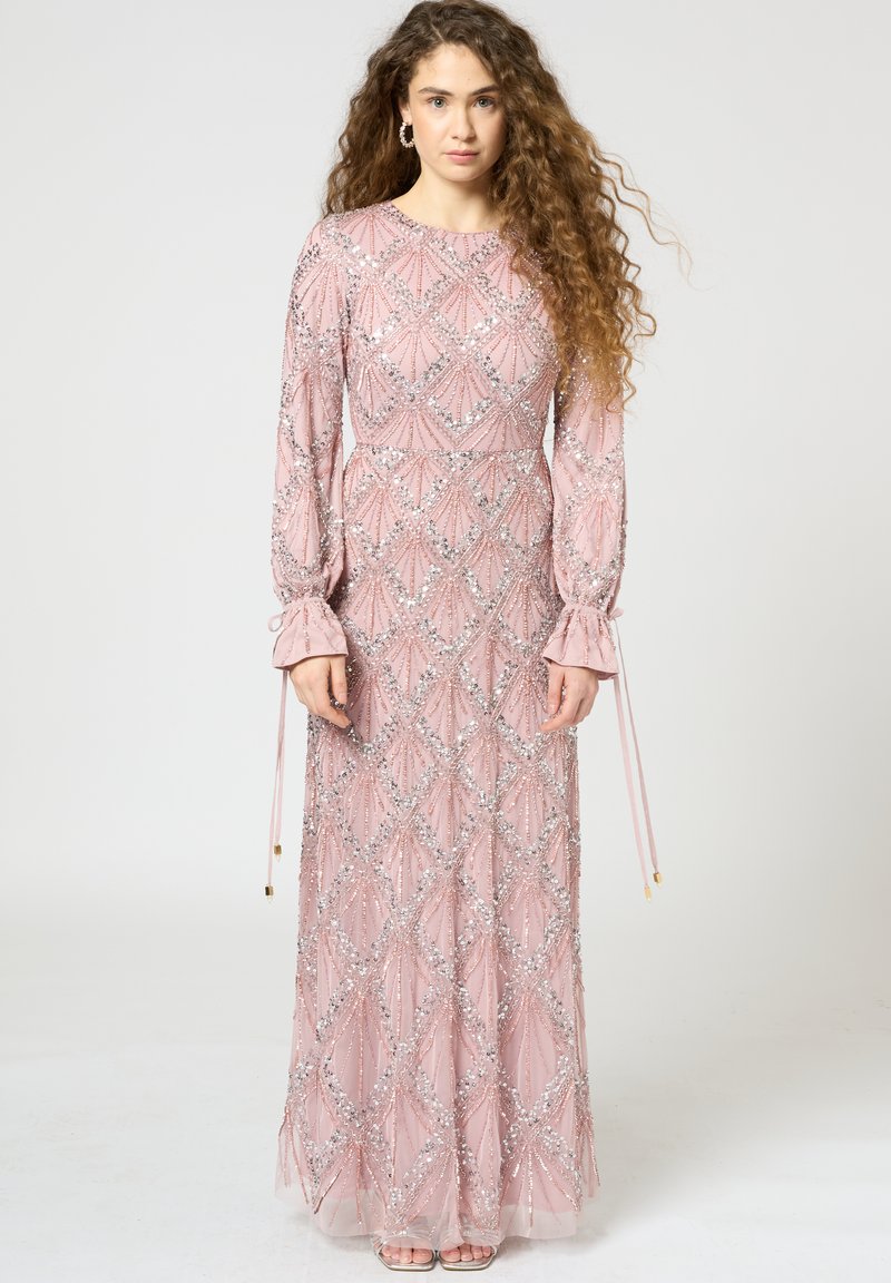 Langärmliges, bodenlanges pinkes Kleid mit einem geometrischen Perlenmuster und silbernen Pailletten. Besitzt ausgestellte Manschetten und eine taillierte Taille.