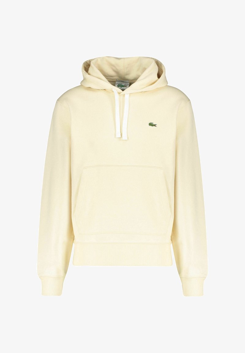 Sweat à capuche beige clair avec poche kangourou à l'avant, cordons blancs et petit logo crocodile vert sur la poitrine.