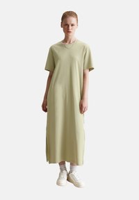 Lichtgroene, korte mouwen maxi-jurk gemaakt van zachte stof, met zijsplits en een relaxed fit. Draag het met witte sneakers en sokken.