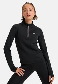 Zwart sporttop met een hoge kraag, kwart ritssluiting en een lichtroze ritssluiting detail. Geweven stof en getailleerd ontwerp.