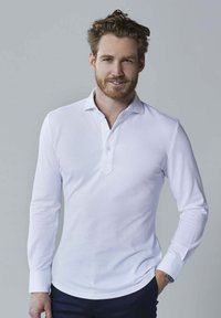 Witte langetermijn polo met een kraag en een drukknoopsluiting van drie knopen, met een gladde textuur en een relaxte pasvorm.