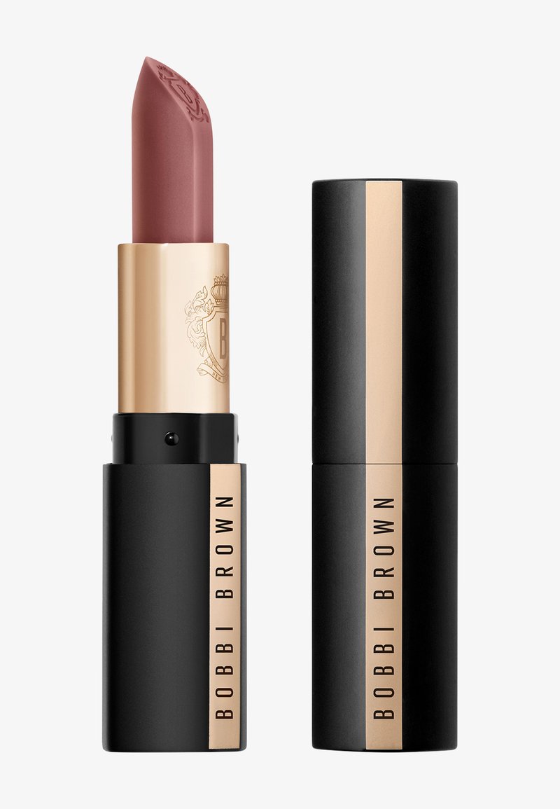 Matowe mauve'owe pomadki Bobbi Brown w złotej i czarnej tubce, jedna otwarta z wyprofilowanym końcem i wytłoczonym logo, obok niej jedna zamknięta.