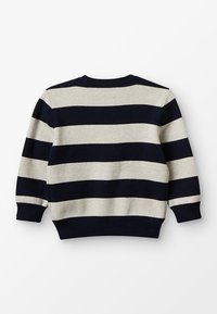 Marinblå och krämrandig tröja med rund halsringning, ribbade ärm- och nederkanter. Mjuk textur, långa ärmar och avslappnad passform.