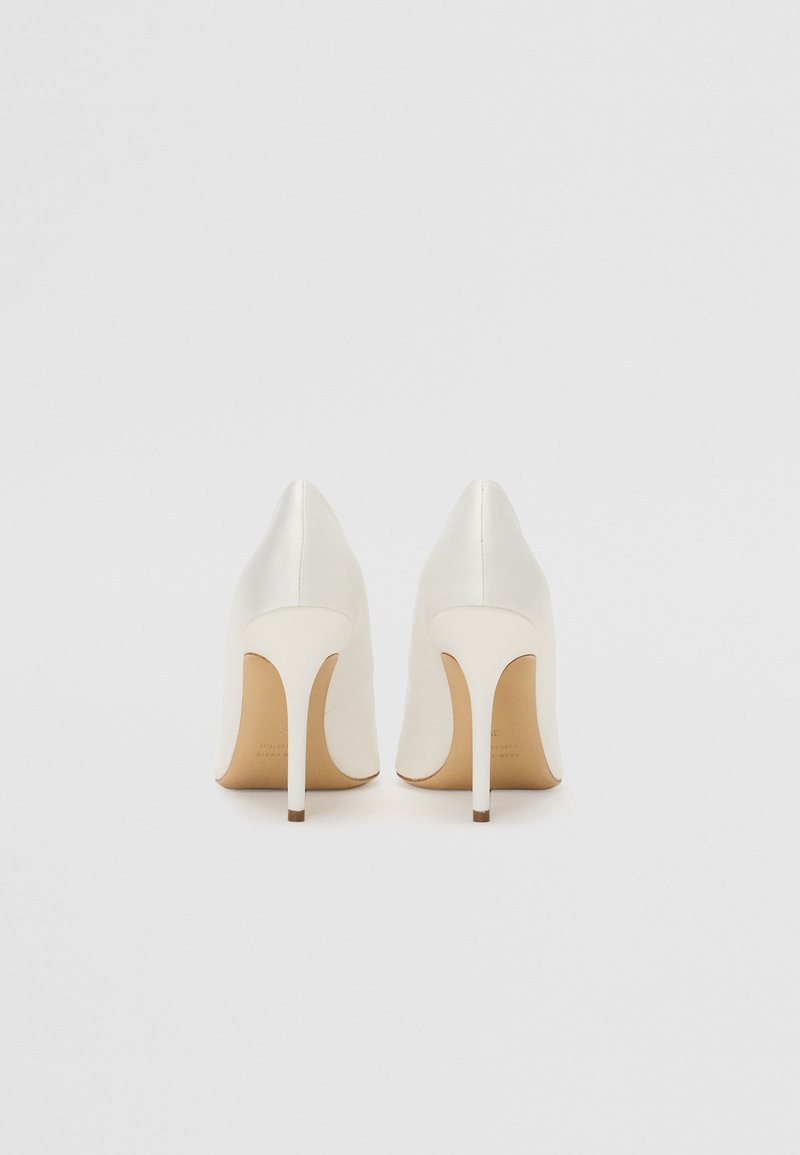 Weiße High Heels mit spitzem Design, glattem Leder und schlanken Stiletto-Absätzen, versehen mit einer beigen Sohle.