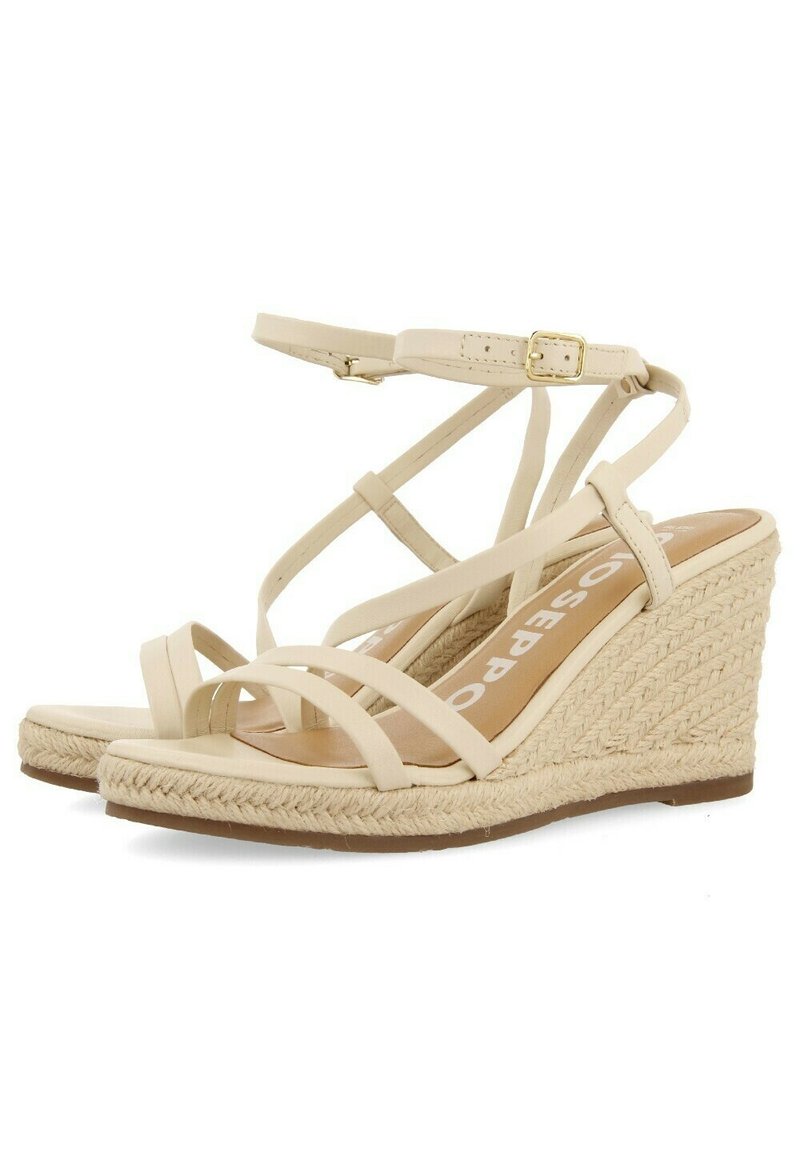 Beige espadrille wedge sandaalit, joissa on punottu juteekorko, useita ristikkäisiä hihnoja ja solki suljenta nilkkahihnassa.