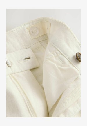 Bežna tkanina pas s gumbom in dvema zankama za pas. Mehka tekstura z vidnimi šivi in čistimi robovi.