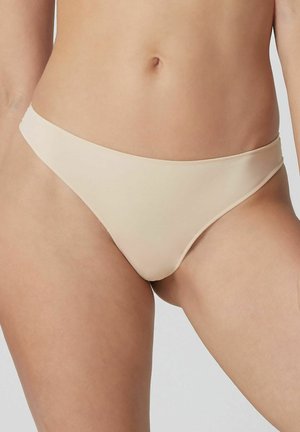 Beżowy dół bikini z gładkiego, elastycznego materiału. Posiada niską talię i minimalne pokrycie oraz bezszwowe krawędzie.