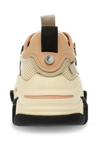 Sneaker chunky con tomaia in rete beige, accenti corallo e neri, suola testurizzata e una linguetta con un'emblema metallico sul retro.
