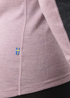 Roze textiel met een gladde textuur, voorzien van een blauw en geel vlagdetail. Contrasterende naad zichtbaar nabij de rand.