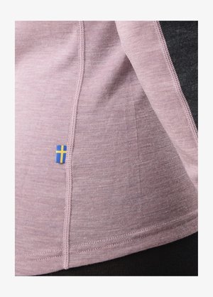 Różowy materiał o gładkiej teksturze, z detalem niebiesko-żółtej flagi. Widoczny kontrastowy szew w pobliżu krawędzi.