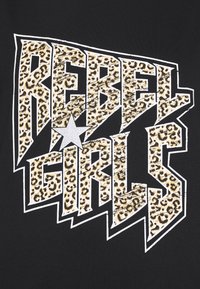 Camiseta negra con el texto en negrita "REBEL GIRLS" en un patrón de estampado de leopardo, destacado por una estrella plateada, sobre un fondo sólido.
