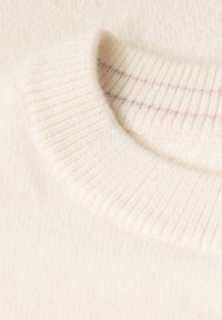 Maglione di colore crema con una lavorazione a maglia testurizzata e colletto a coste, caratterizzato da una sottile striscia rosa all'interno del scollo per un tocco di dettaglio.
