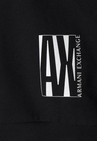 Felpa nera con un grande logo bianco di Armani Exchange, con lettere in grassetto e testurizzate all'interno di un contorno rettangolare e orlo a coste.