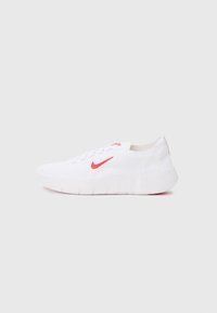 Hvide atletiksko med en tekstureret strikoverdel, rødt Nike swoosh-logo, snørebåndsdesign og hvid gummisål med grip-linjer.