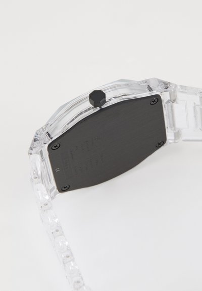 Clear plastic wristwatch with a black metal back and a hexagonal crown. The strap features links that match the transparent case.
