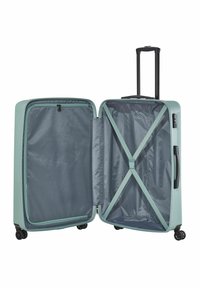 Valise rigide vert clair avec une poignée noire rétractable, quatre roues et un intérieur en tissu gris avec des sangles croisées pour les contenus.