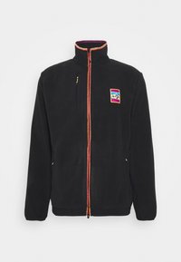 Černá fleecová bunda se zipem vpředu, vysokým límcem a oranžovo-červeným detailem na zipu. Obsahuje přední kapsu a vícebarevnou nášivku s logem.