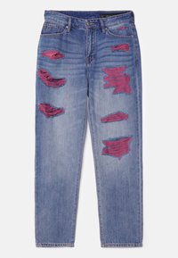 Džínové kalhoty světle modré barvy s odřeným vzhledem. Obsahují velké díry zvýrazněné vínovou tkaninou. Klasický rovný střih s tradičním pětimístným stylu kapsy.