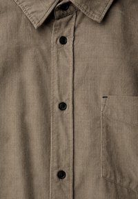 Brown corduroy shirt with a button-up front, five black buttons, and a left chest pocket. Features vertical ribbed texture.