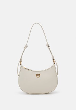 Beige nahast käekott, millel on kõver kuju, kuldne logoembleem ja reguleeritav rihm. Sile tekstuur ning lukuga sulgemine ülaosas.