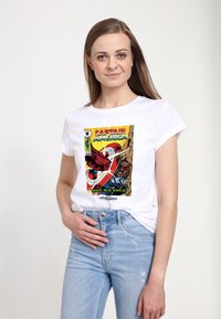 Bílý bavlněný tričko s barevným grafikou komiksového umění Kapitána Ameriky, s výrazným textem "ODVAŽNÝ NOVÝ SVĚT!" a opotřebovaným designem.
