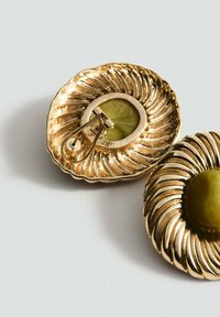 Goudkleurige bloemenvormige broches met een gestructureerd ontwerp en een centrale groene steen, voorzien van een veilige metalen sluiting aan de achterkant.