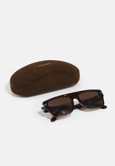 Ochelari de soare din tortois cu lentile maro, cu accente de hardware argintii. Vine cu o husă din suede maro, inscripționată cu "TOM FORD."
