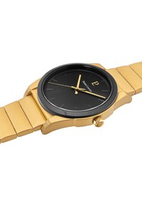 Reloj de metal dorado con un dial negro, agujas doradas e índices. Presenta una pulsera suave con un cierre desplegable y una caja redondeada.