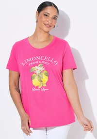 T-shirt rose à manches courtes, présentant un graphique de citron avec des feuilles et des fleurs, accompagné du texte "Limoncello Frais et Juteux" et "Liqueur de Citron".