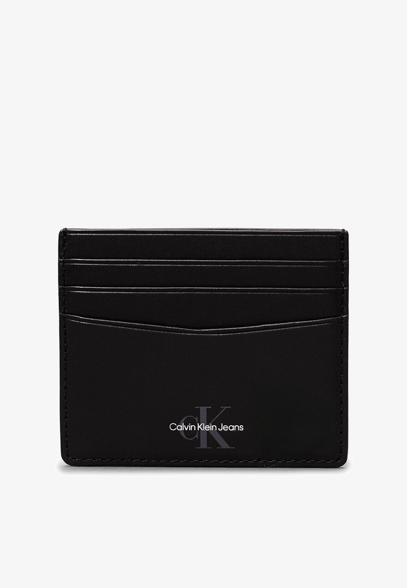 Black leather cardholder featuring six card slots, a textured finish, and embossed "Calvin Klein Jeans" logo on the front.