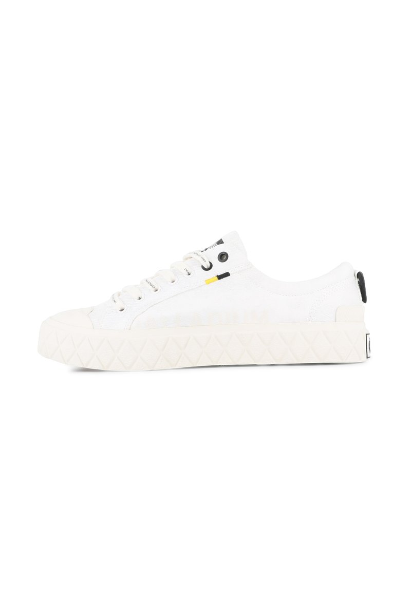 Vita canvas-sneakers med en texturerad sula, rund tåhuvud och svarta detaljer; har vita snören och en liten logotyp bak.