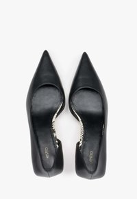 Černé kožené lodičky s špičatou špičkou a výřezovými detaily, s hladkým povrchem a kontrastní vzorovanou stélkou. Logo značky viditelné uvnitř.