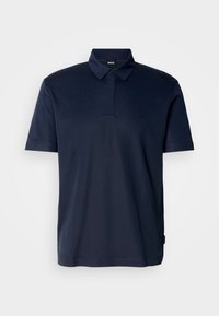 Polo à manches courtes bleu marine avec col, un bouton et un logo embossé subtil sur la poitrine gauche, sur fond uni.