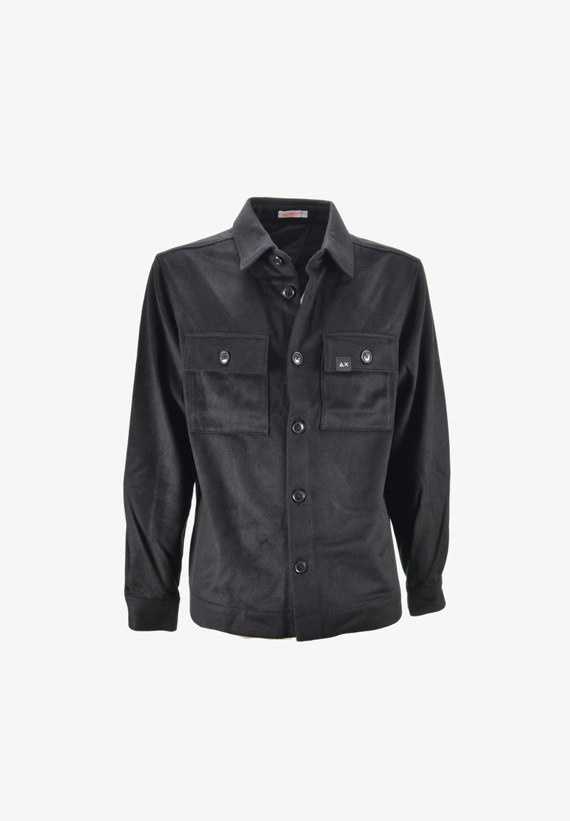 Camicia nera con bottoni realizzata in tessuto morbido, con due tasche sul petto, chiusura a bottoni e maniche lunghe. Etichetta di marca ben visibile sulla tasca.