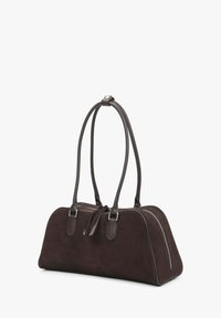 Sac en daim marron foncé avec une forme arrondie, deux poignées en cuir et des accents de fermeture éclair argentés. Doté d'une texture lisse et d'un design minimaliste.